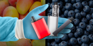 background of mangoes and blueberries. blue-gloved hand overlaid, holding 3 different vapes.