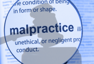 Magnifying glass over the definition of "malpractice." Shadow of a gavel overlayed.